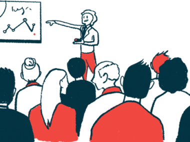 A presenter points to a chart on the wall while sharing data at a conference.