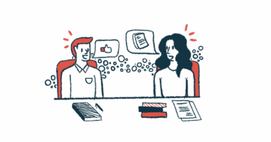 Two people sit at a table talking.