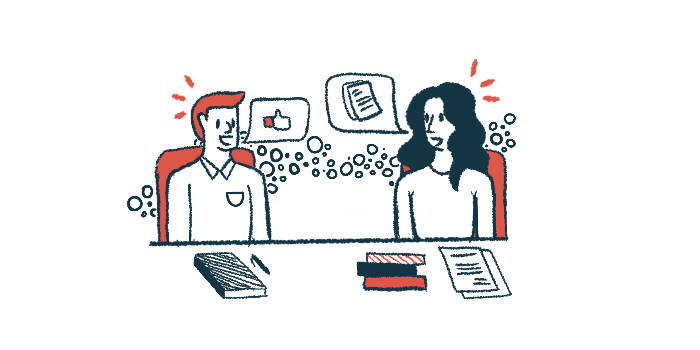 Two people sit at a table talking.