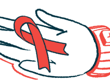 A hand holds a red awareness ribbon.